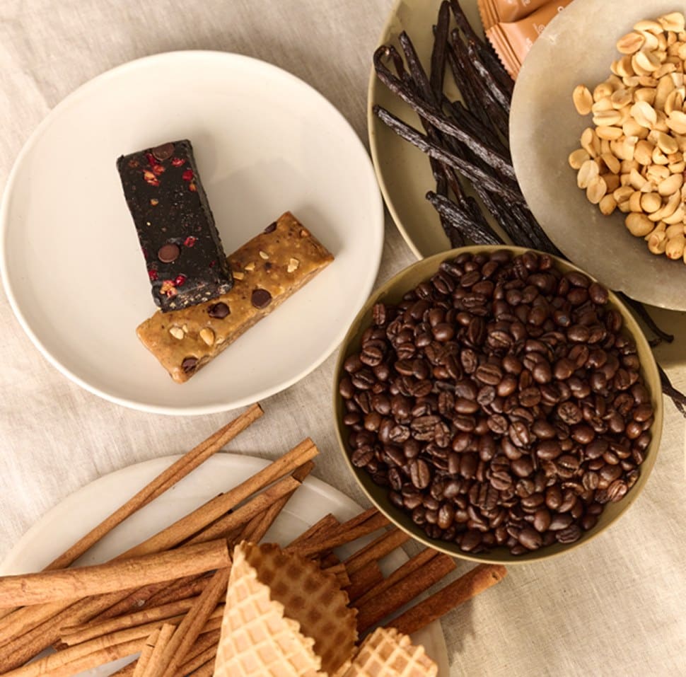 Two Stars + Honey bars on a plate with coffee beans, vanilla pods, peanuts, cinnamon sticks and waffle cones