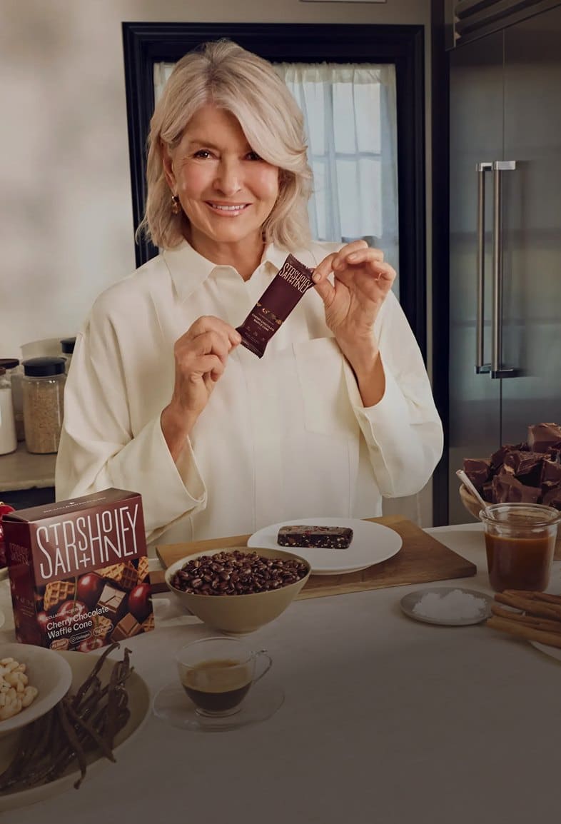 Martha Stewart in her kitchen holding a Stars + Honey bar